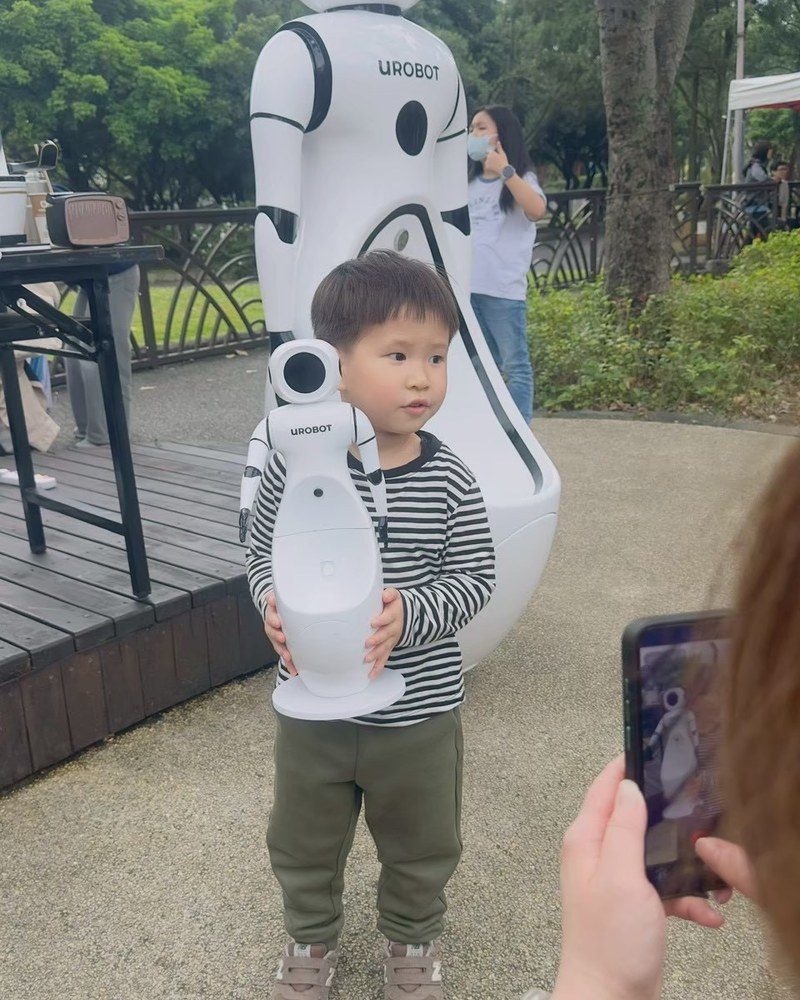 A young visitor holding a mini UROBOT